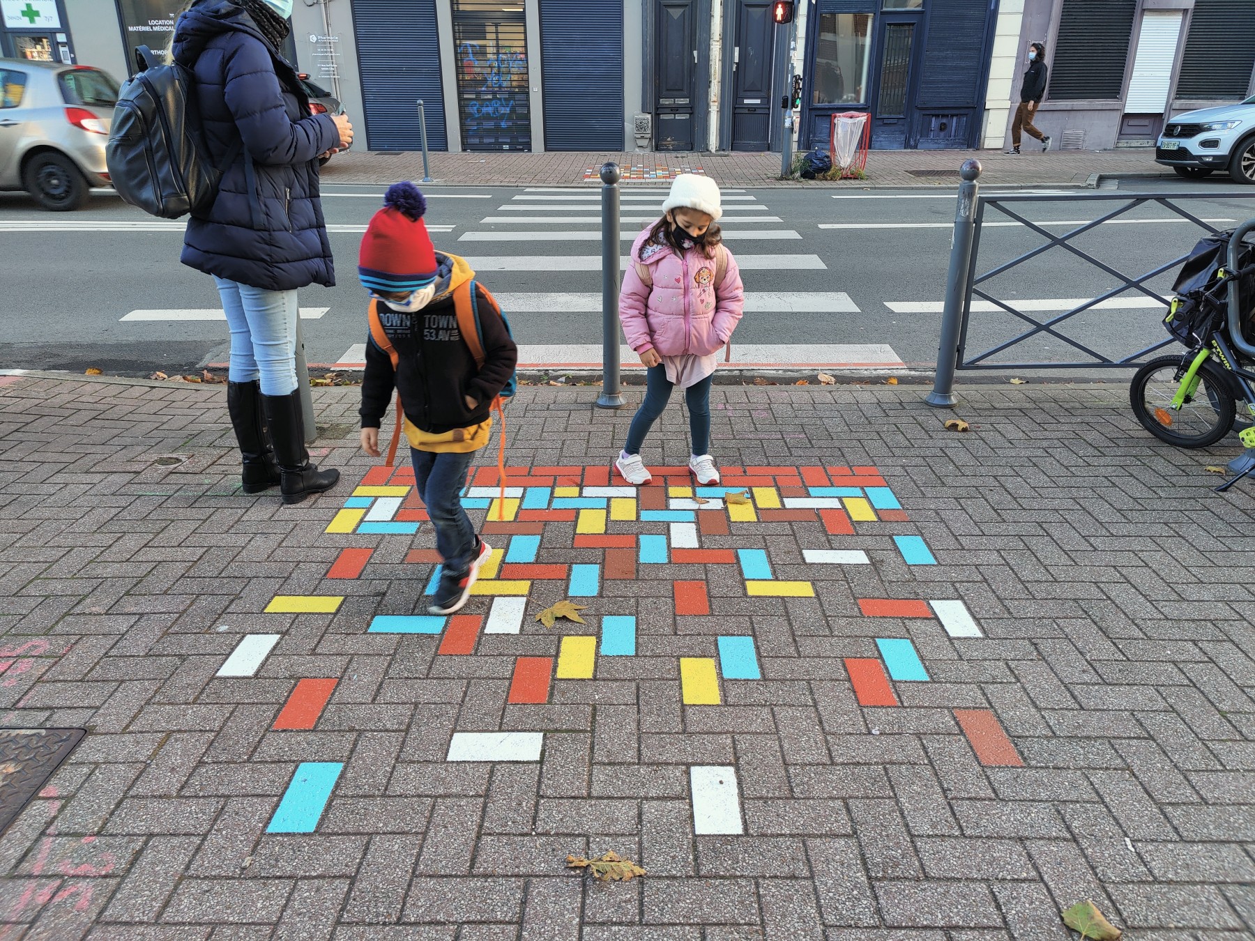 Photo d'enfants jouant dans la rue sur des pavés colorés